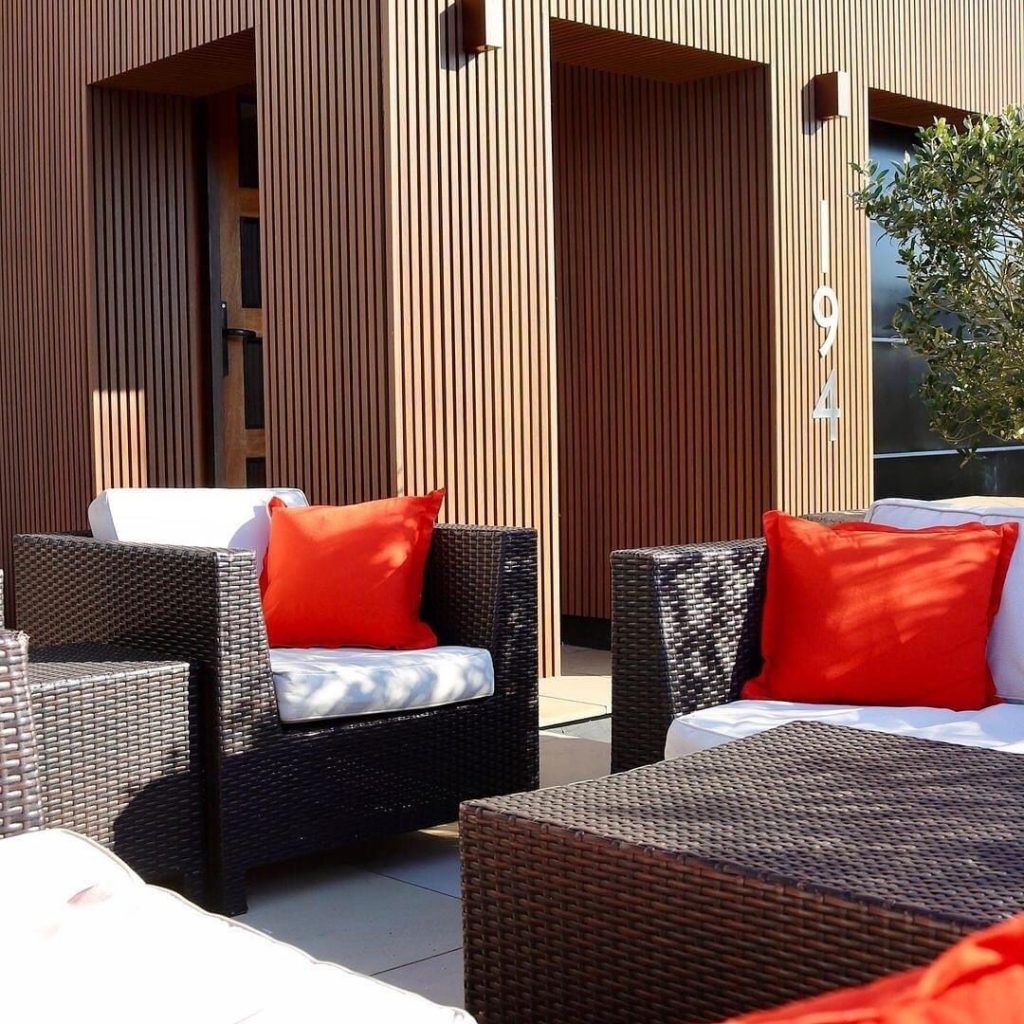 Sunlit outdoor wall with Golden Teak WPC fluted panels